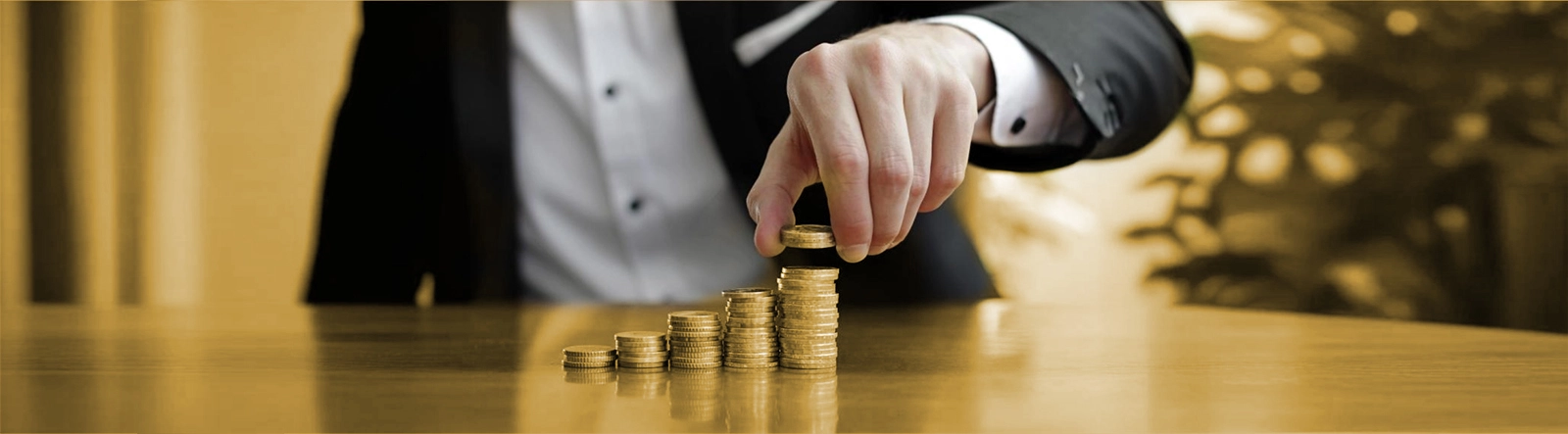 Article cover image depicting a person making stacks of coins.