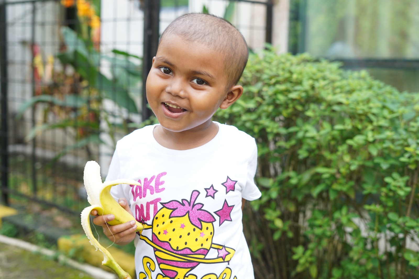 Cuddles featured image depicting a child smiling and eating a banana