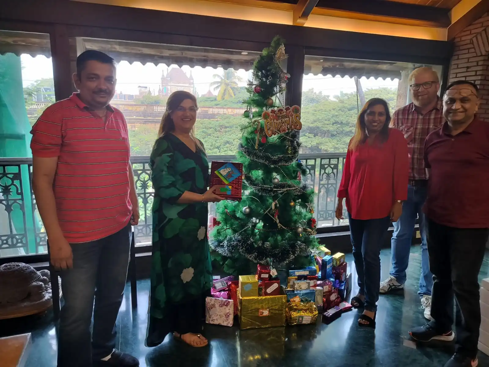 Alchemy team posing next to a Christmas tree.