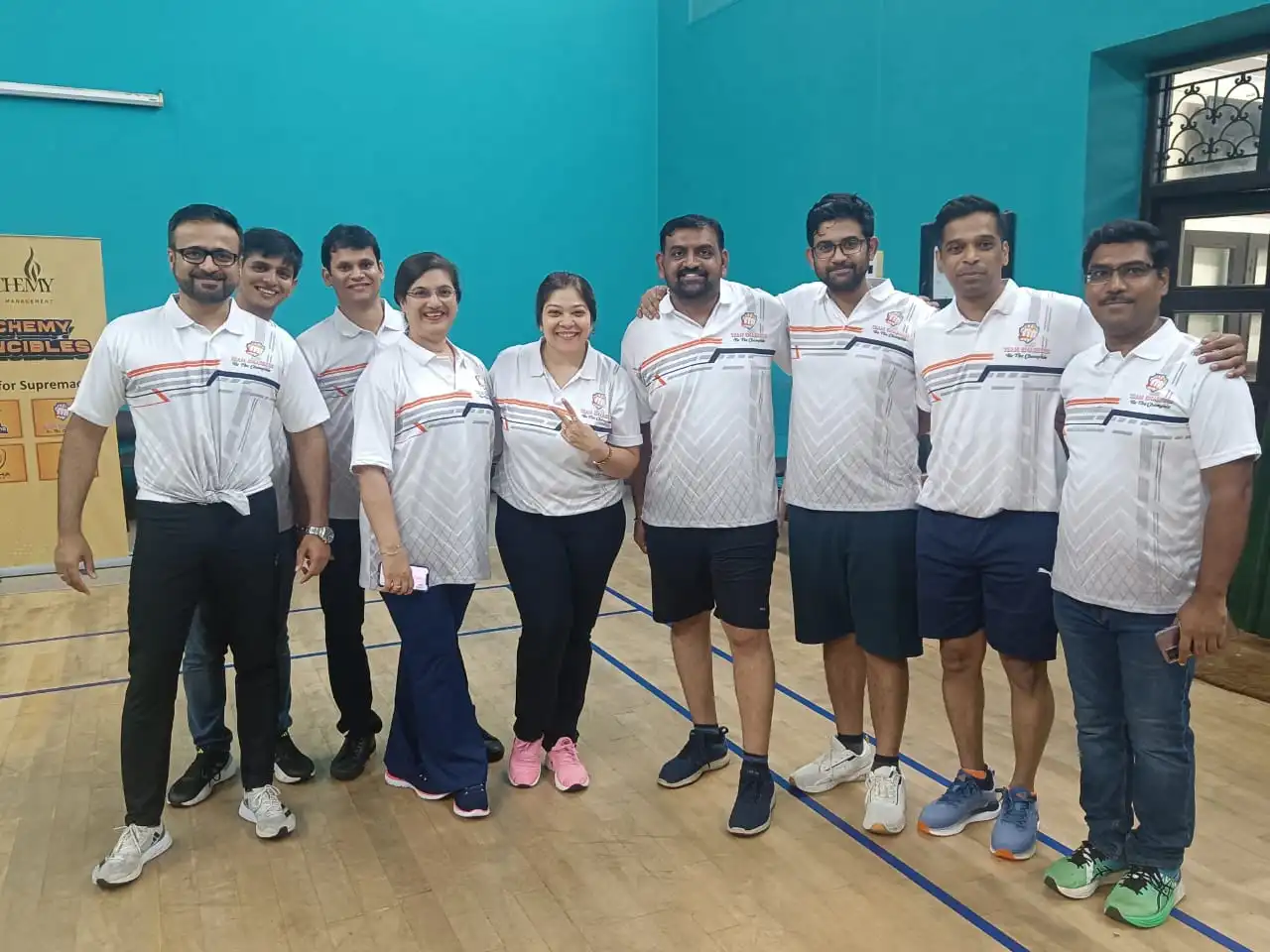 Alchemy team in sports wear smiling for a picture.